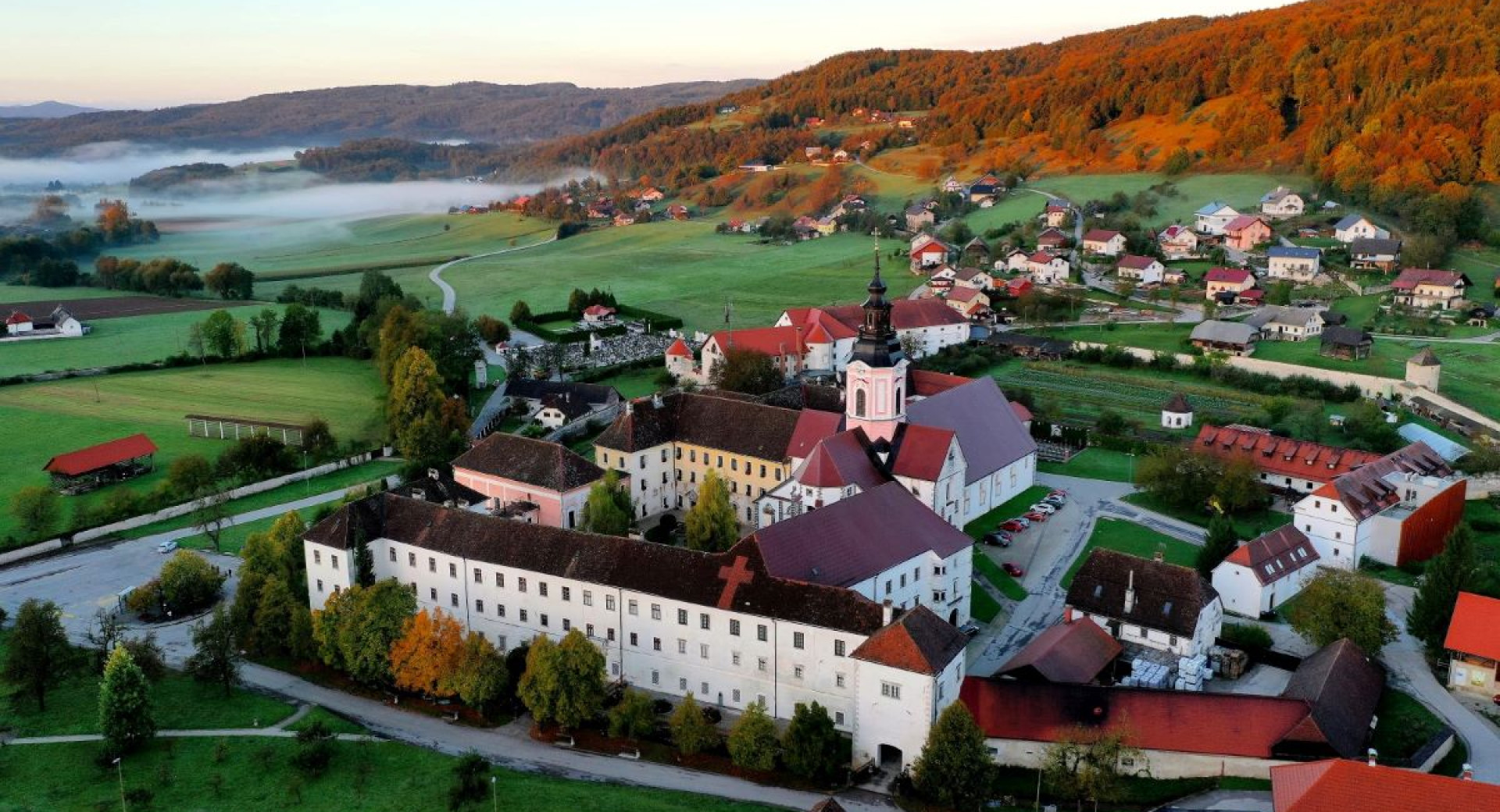 A panorama of a village with a hilly background.