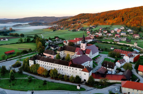 A panorama of a village with a hilly background.