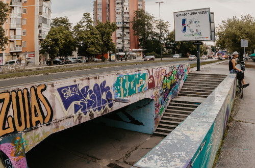 Graffiti-covered underpass in an urban setting.