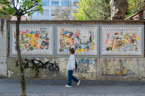 A woman walking down a street decorated with graffiti and three wall-mounted photographs.