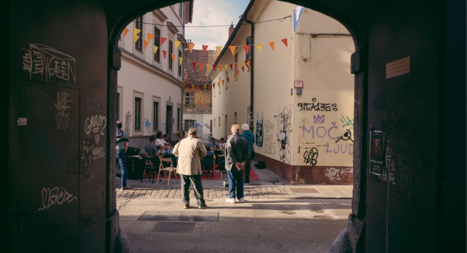 View of a street with people through a dark archway.