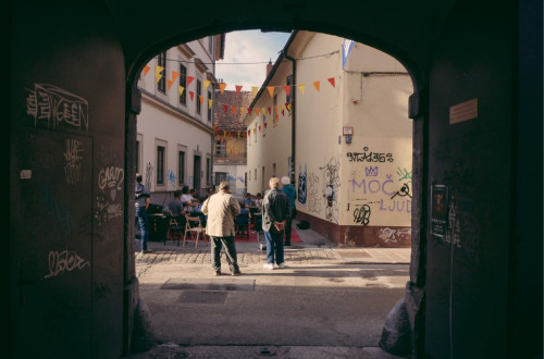 View of a street with people through a dark archway.