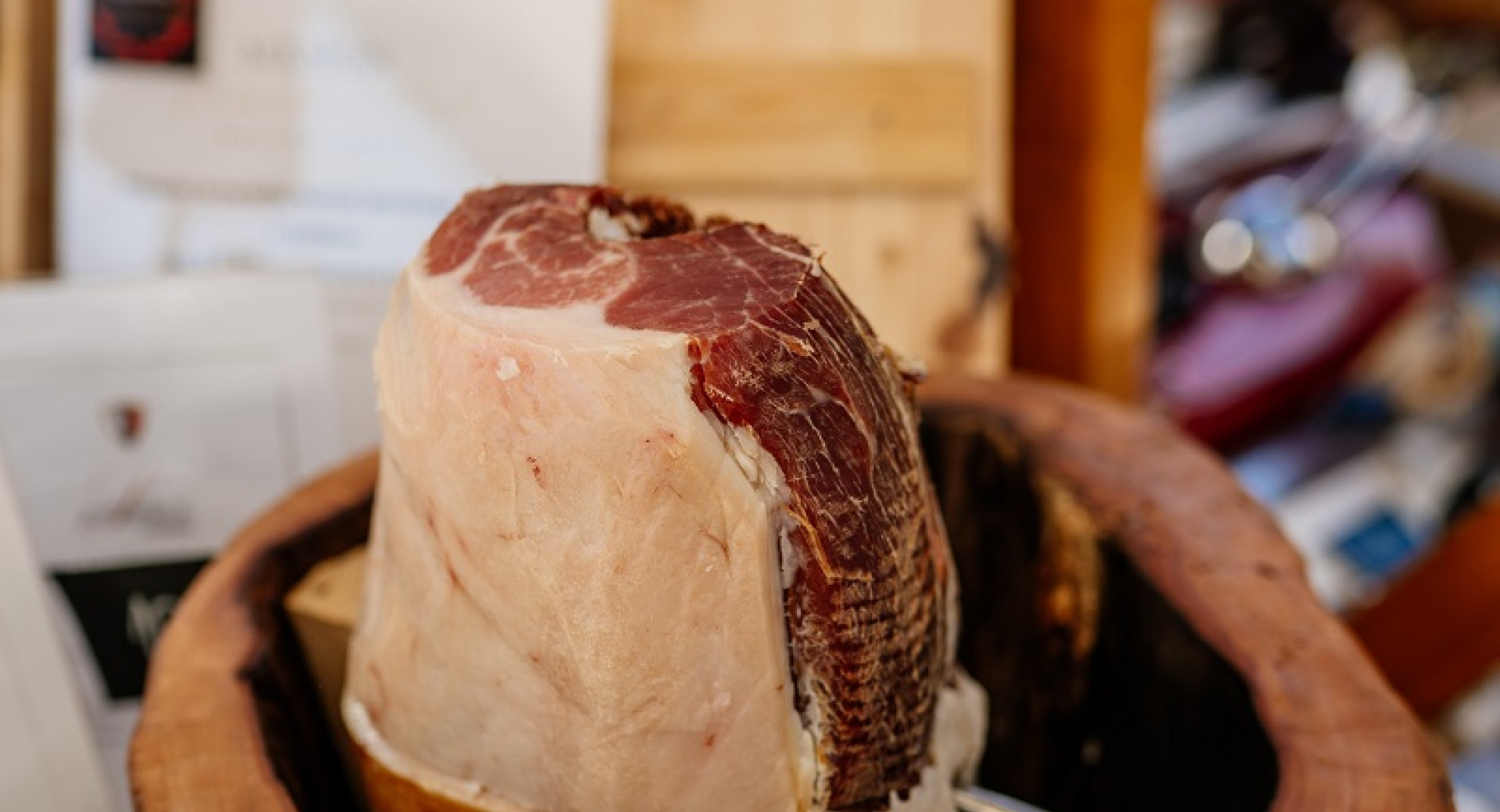 A basket in the shape of a brown trunk with a whole piece of prosciutto in the middle.