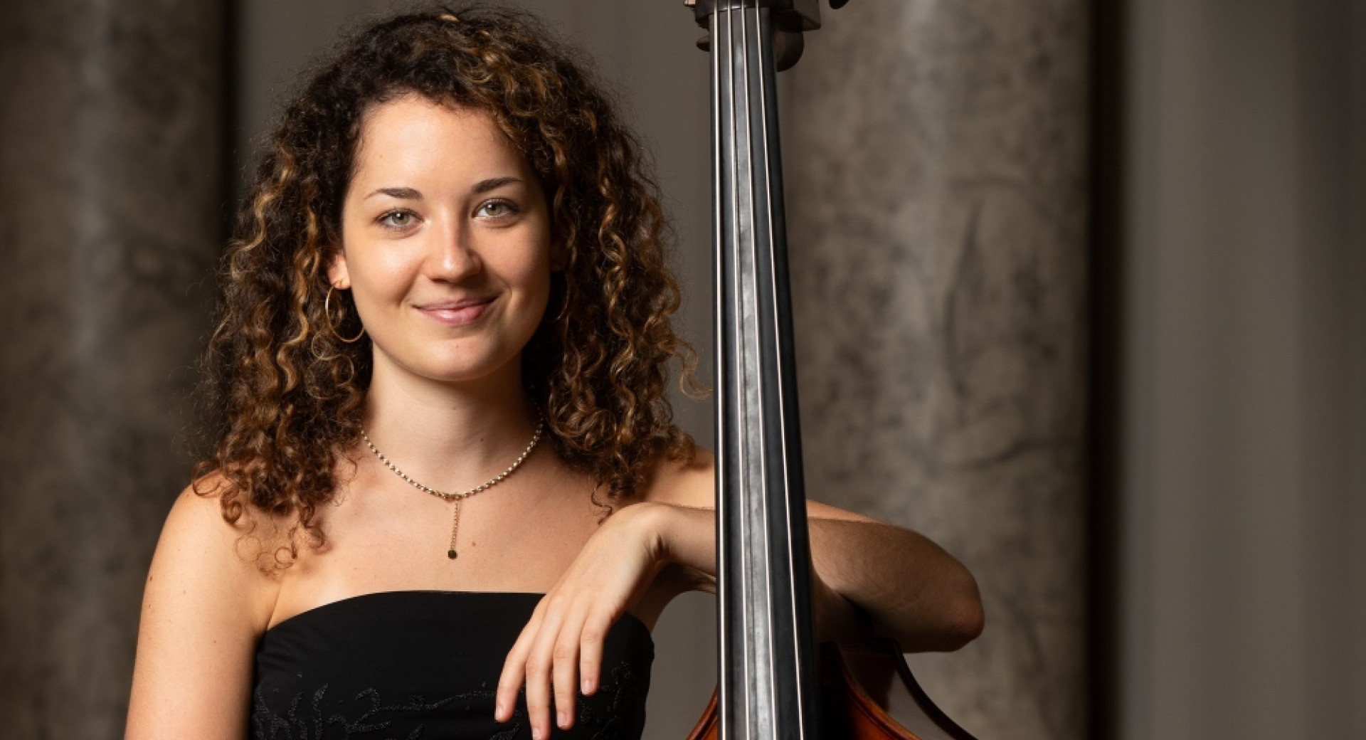 Woman leaning on double bass.