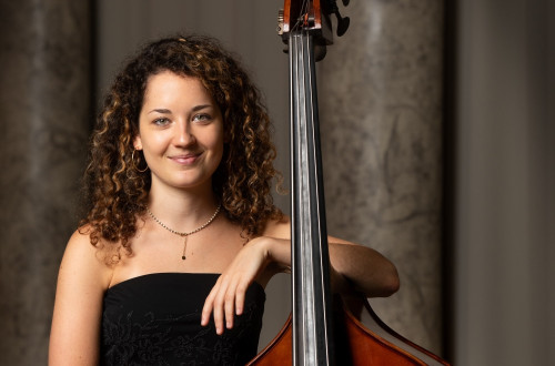 Woman leaning on double bass.