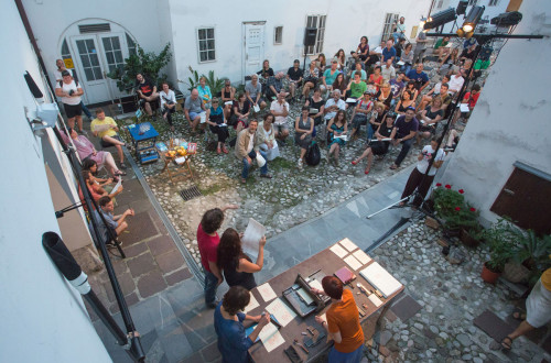 A group of people gathered on a street between houses.