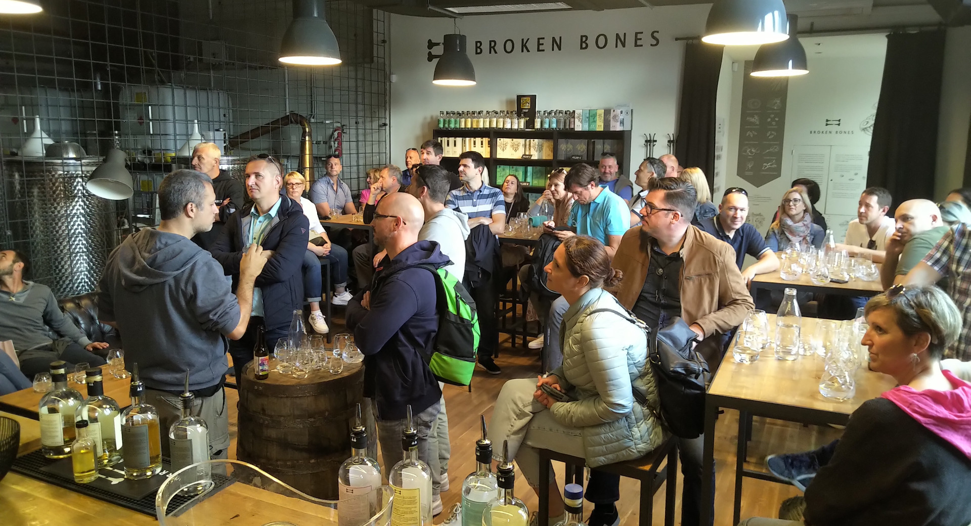 People are seated at bar tables, chatting over drinks.