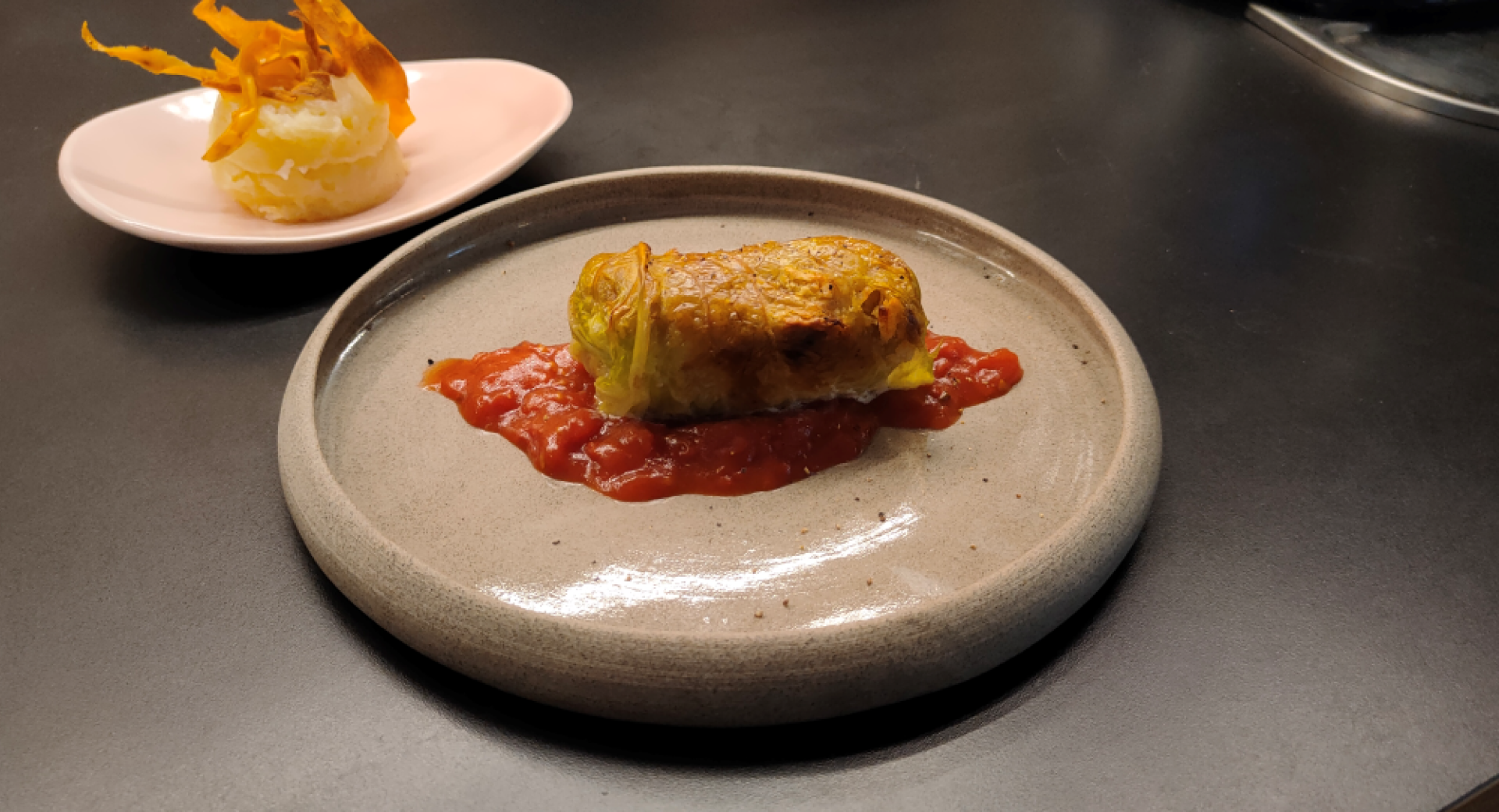 A plate features a wrap served on a tomato sauce.