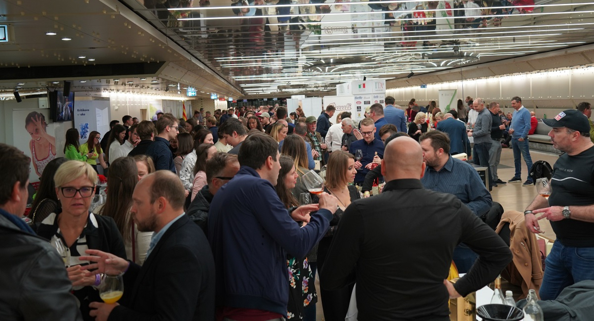 A crowd of people in a room with a low ceiling.