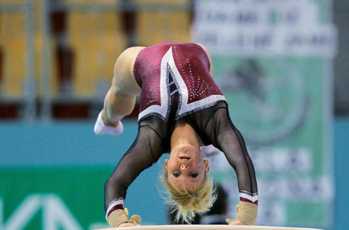 A girl performing a gymnastics vault.