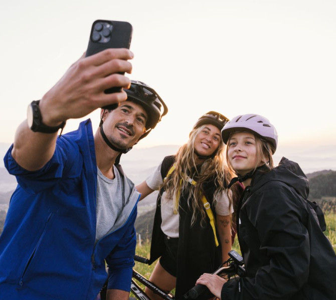 Tri-clanska druzina dela selfie z ozadjem hribovij.