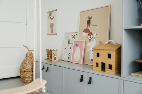 A children's room with cute animal illustrations on the walls, wooden toys, and colorful decorations.