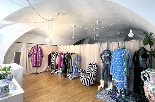 A fashion boutique with unique garments on display, featuring bold patterns, polka dots, and artistic decor.