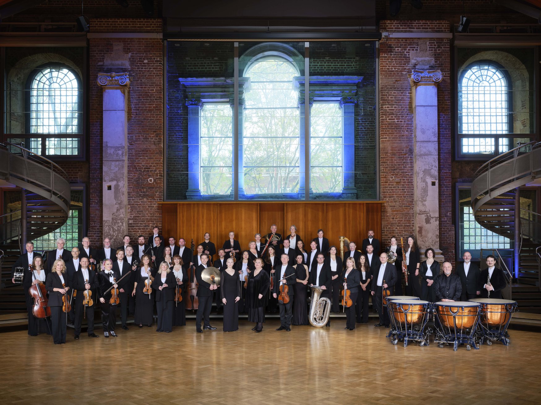 skupinska slika orkestra v poslopju z velikimi okni