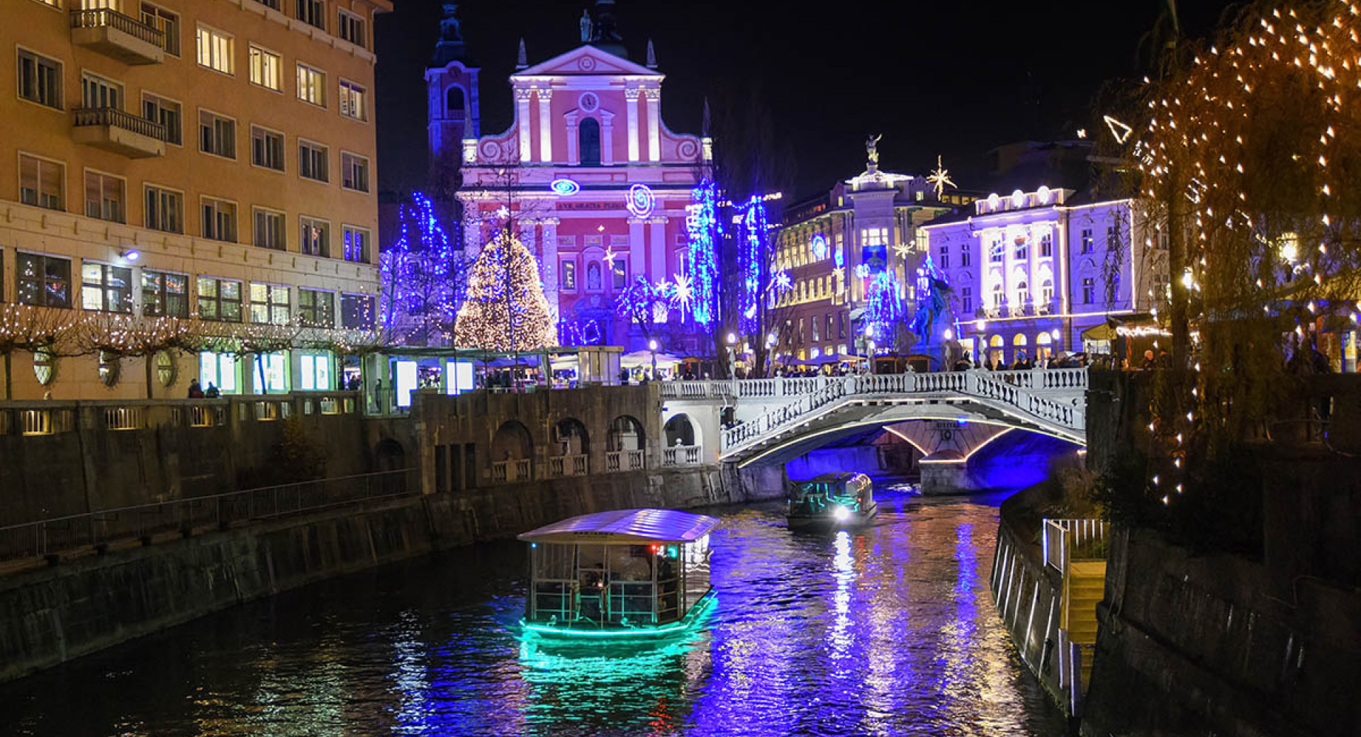 Praznično okrašen Prešernov trg, Tromostovje, ladjica in drevesa.