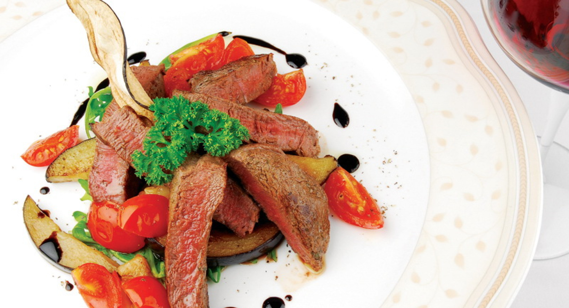 Plated dish consisting of vegetables and pieces of meat.