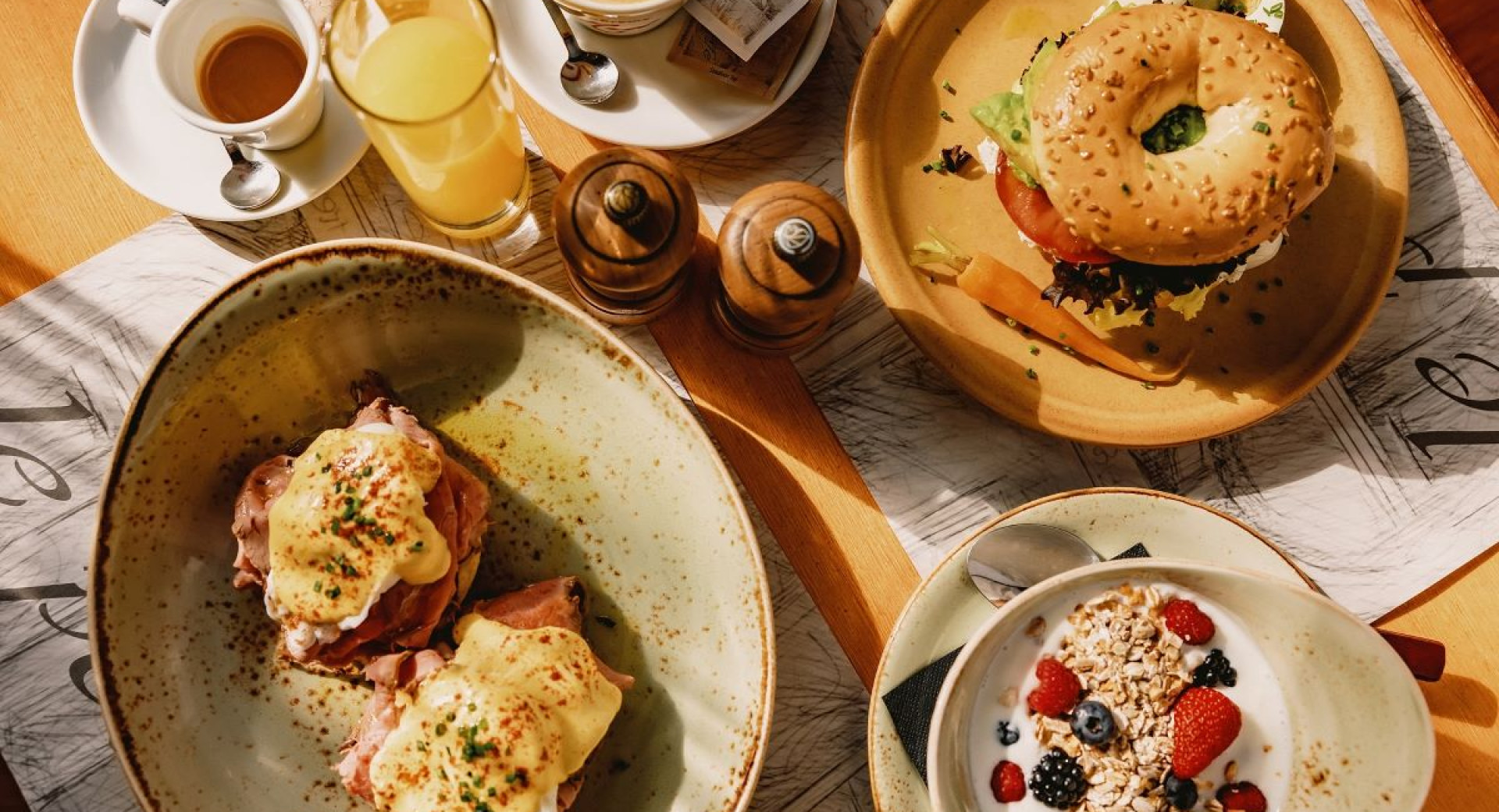 Brunch food on the table: a sandwich, cereal, eggs, and a drinks.