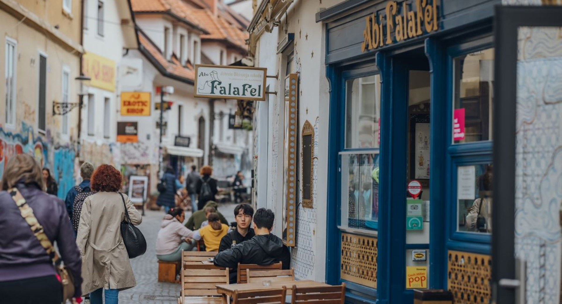  People sitting on chairs in a busy street.