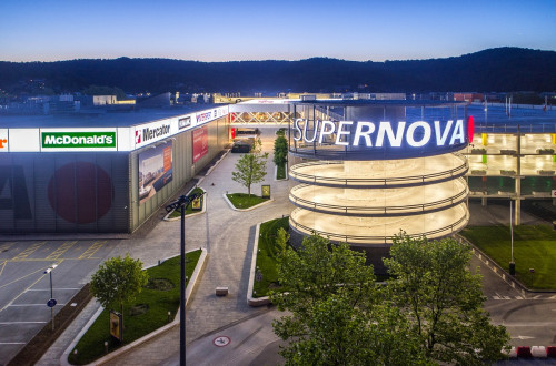 A distant view of an illuminated shopping complex on a large area.