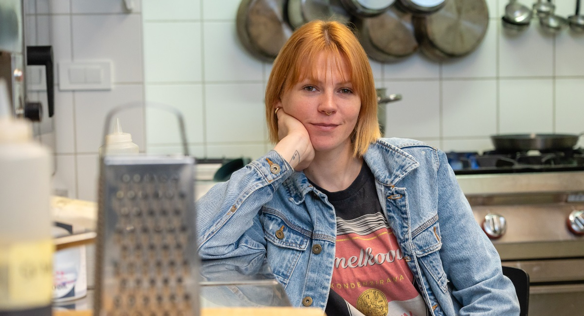 A woman with orange hair in a blue jacket.