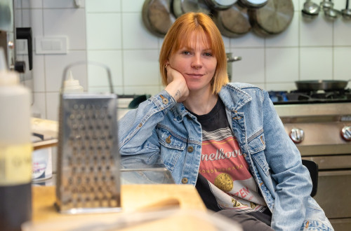 A woman with orange hair in a blue jacket.