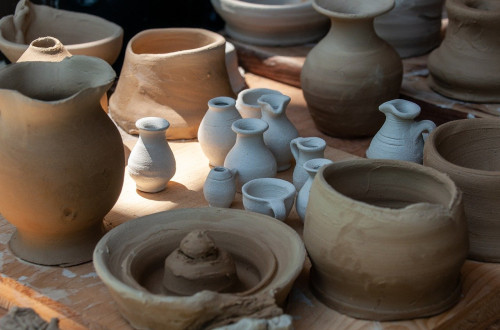 Various pieces of clay ceramics in different shapes and colours, including jugs, vases and bowls.