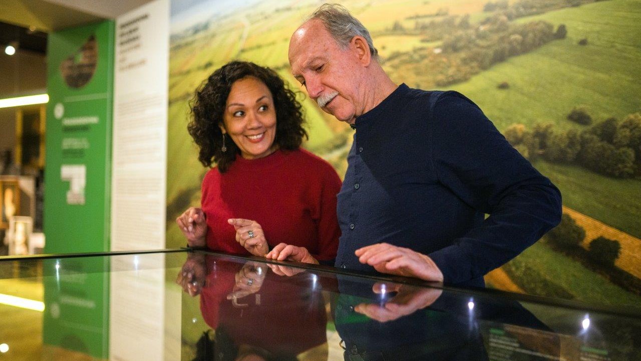  An elderly couple is looking at an exhibition in a museum.