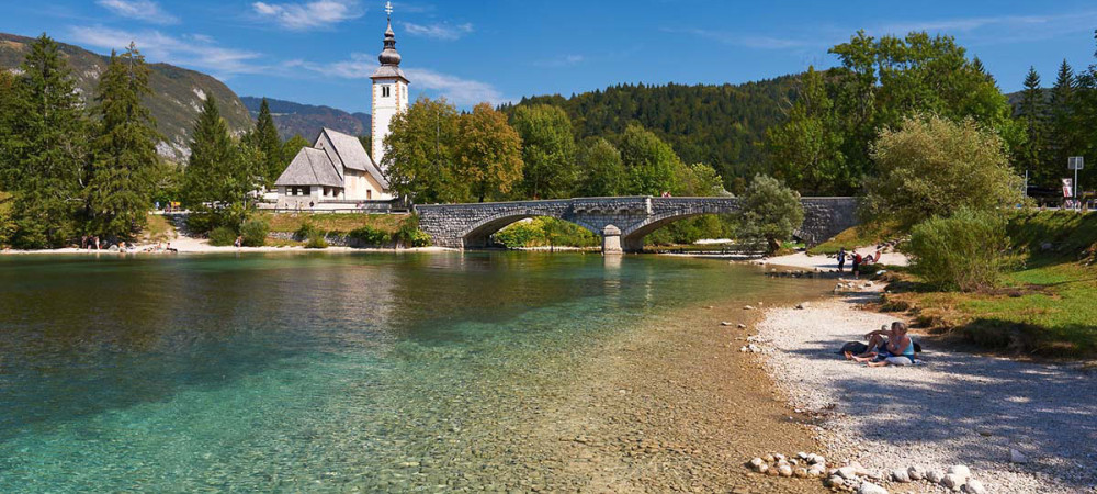 Bohinjsko jezero. V ozadju cerkev sv. Janeza Krstnika in most.