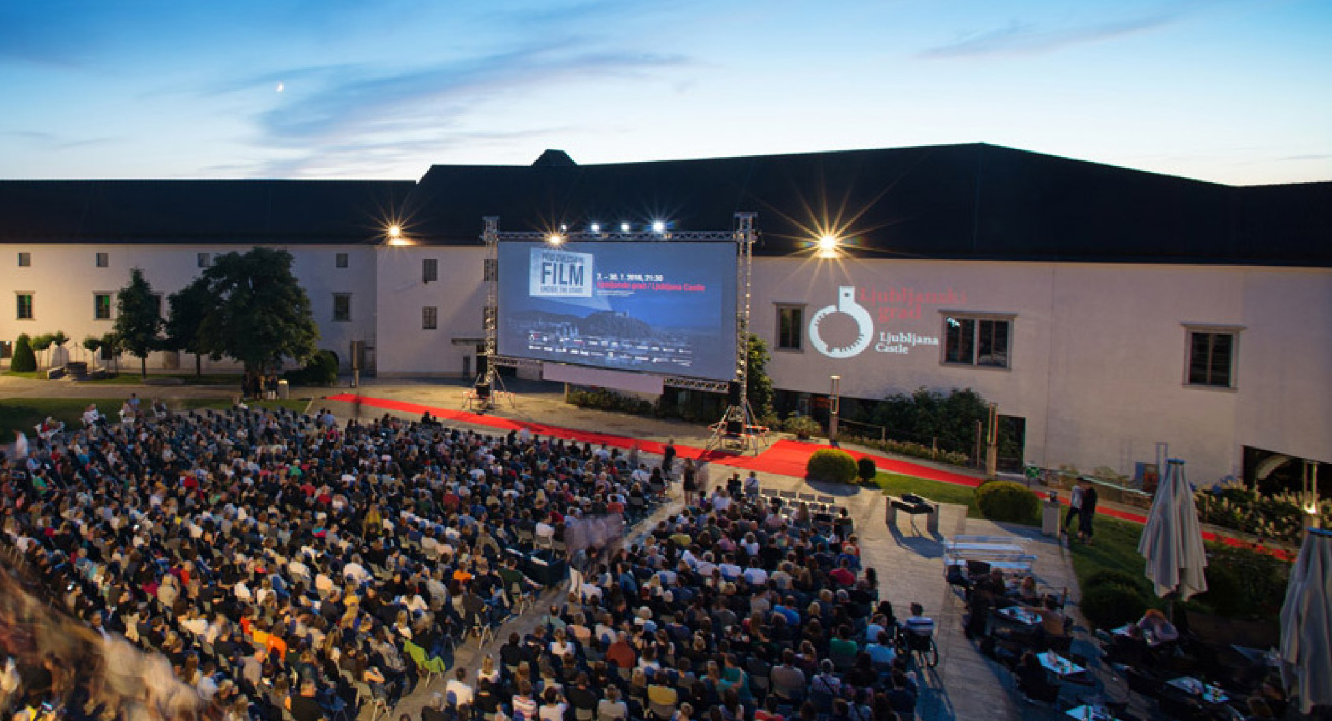 Gledalci projekcije filma na dvorišču Ljubljanskega gradu v okviru prireditve Film pod zvezdami.