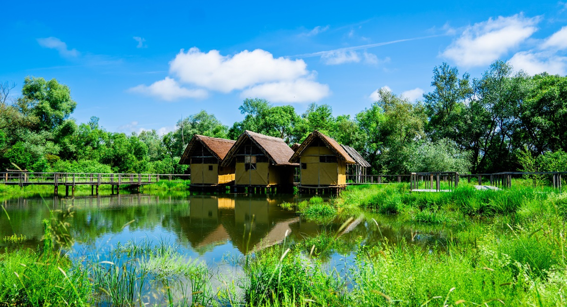 Three houses on piles surrounded by water.