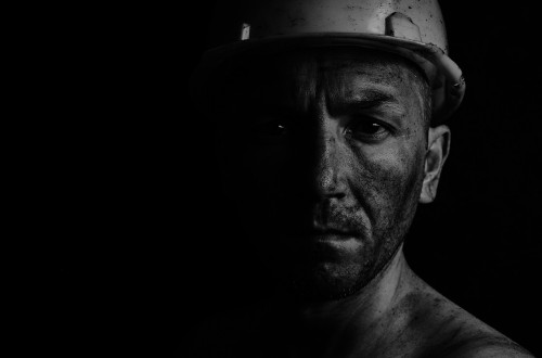A dirty face of a miner on a black background.