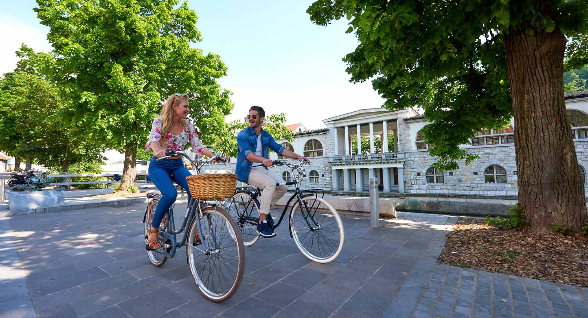 Kolesarja ob Ljubljanici. Za njima Plečnikova glavna tržnica.